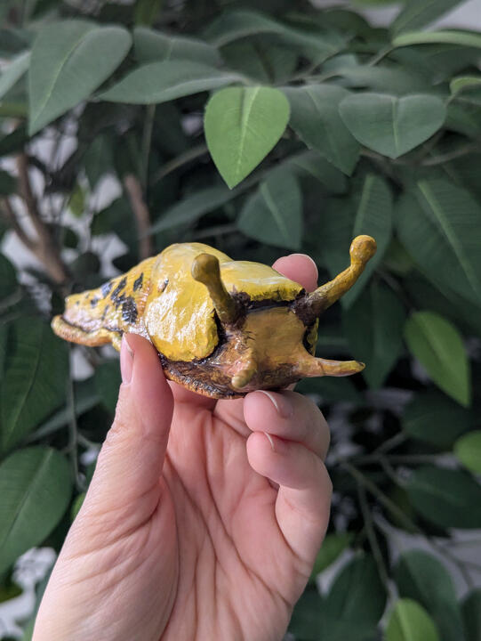 Banana slug clay sculpture painted with acrylic and sealed with gloss varnish