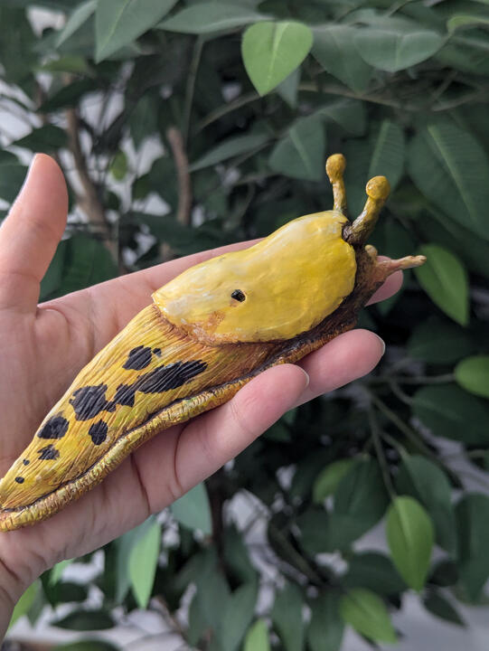 Banana slug clay sculpture painted with acrylic and sealed with gloss varnish